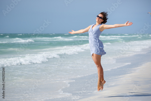 Beautiful woman jumping on Florida Beach photo