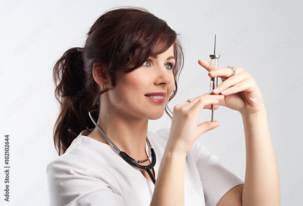 Beautiful lady doctor with stethoscope and syringe preparing to make injection. Beautiful lady doctor with stethoscope and syringe preparing to make injection.