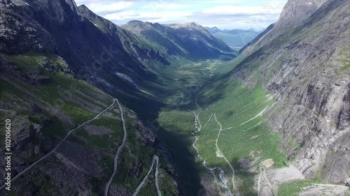 Scenic aerial view of Trollstigen pass road in Norway surrounded by stone walls with waterfalls, major tourist attraction. Aerial 4k Ultra HD.