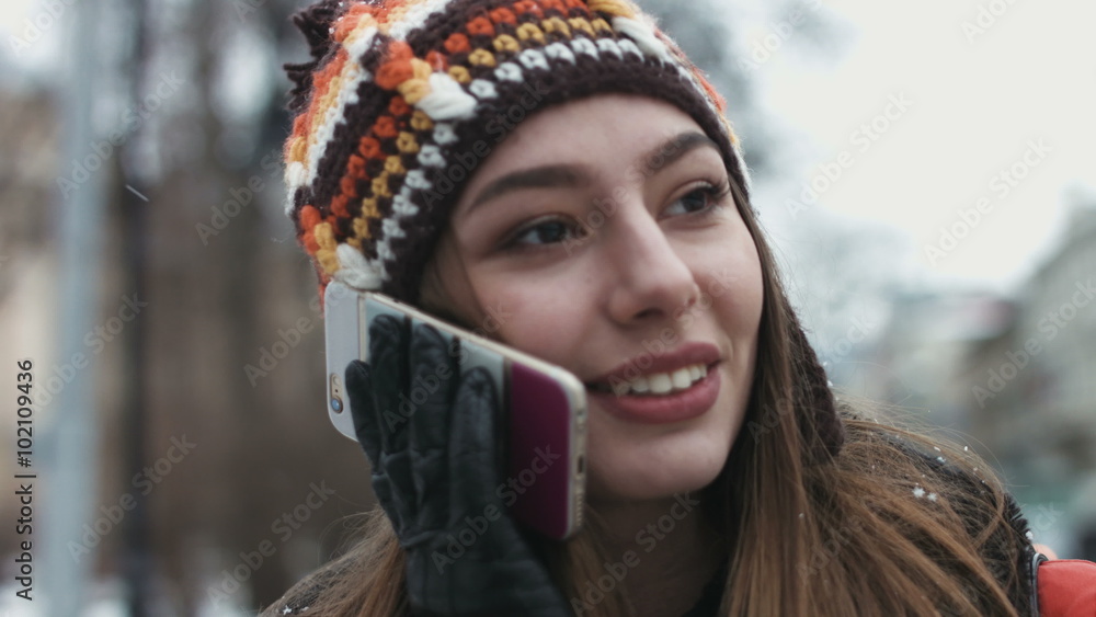 Close-up portrait of a funny girl talking on her mobile device outdoors. Close-up portrait of a funny girl talking on her mobile device outdoors.