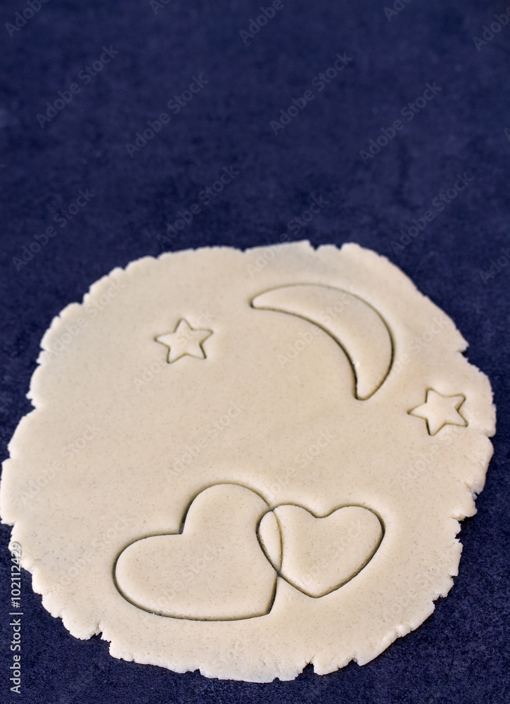 Two crossed hearts on round dough with moon and stars