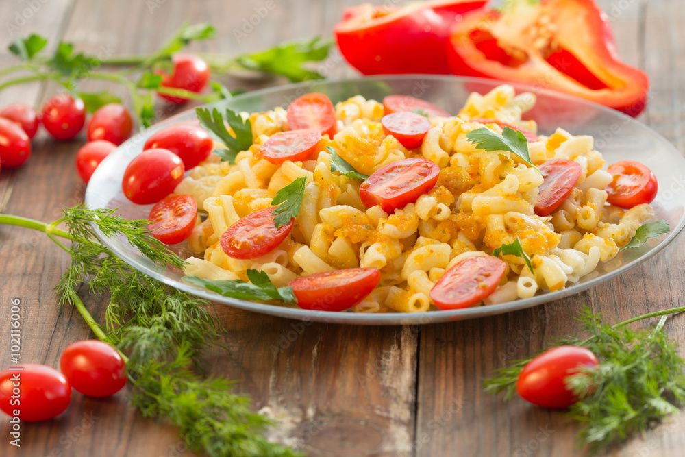 Macaroni pasta in vegetable sauce with fresh tomatoes and parsley on wooden dark background. Vegetarian o healthy food concept
