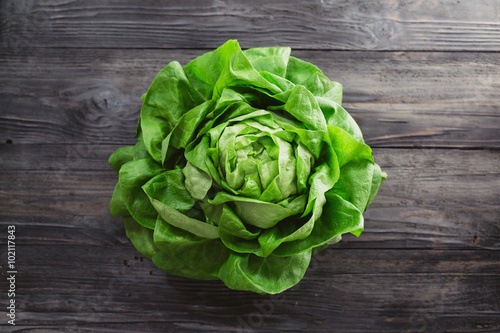 Canvas Print Single lettuce head over rustic wooden background