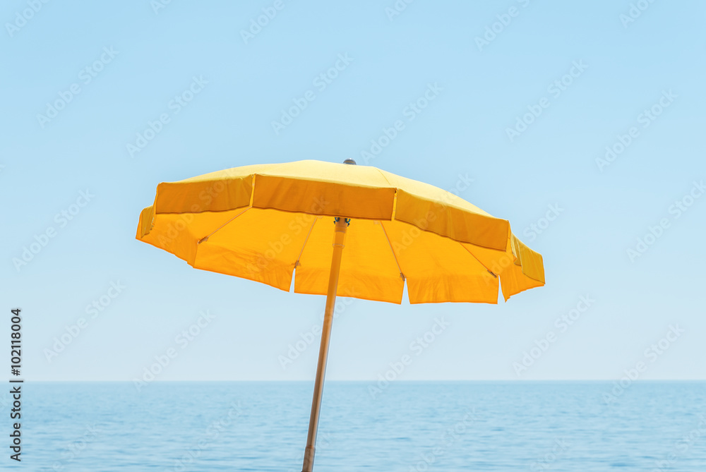 yellow umbrella near sea under blue sky