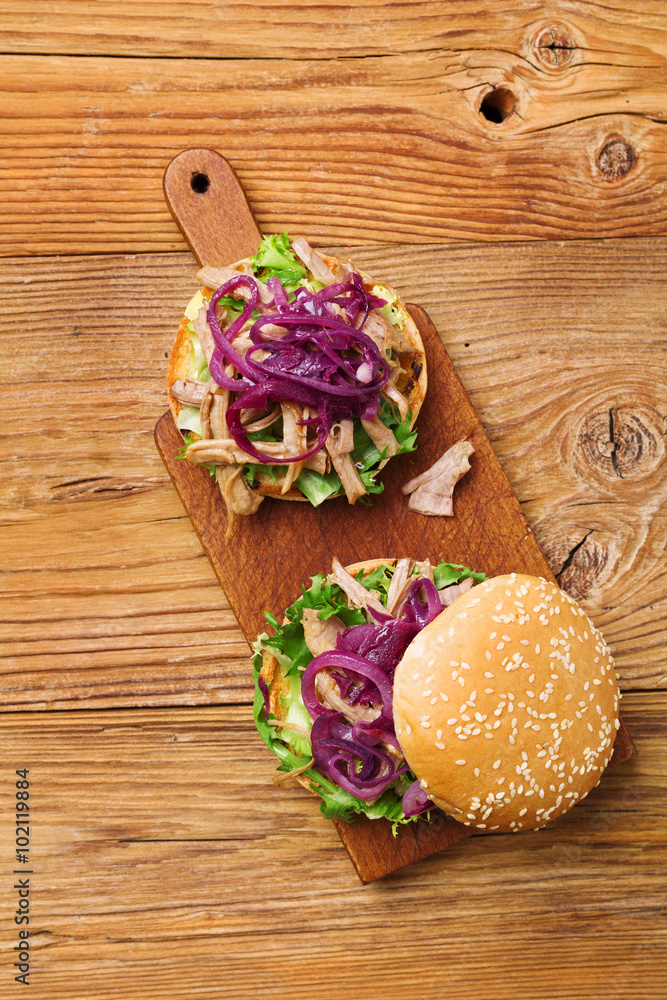 Burger with meat of duck with red onion and lettuce. Burger with meat of duck with red onion and lettuce.