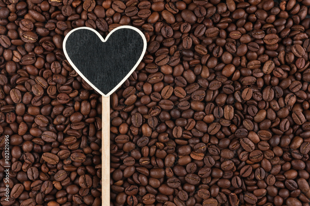 Pointer in the form of heart lies on coffee beans Pointer in the form of heart lies on coffee beans