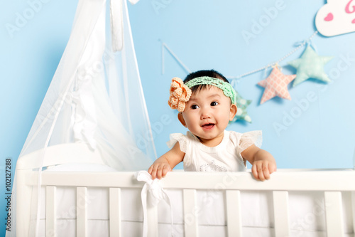 little girl standing in a crib
