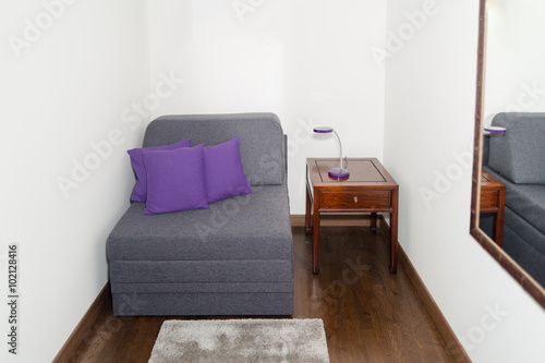 Comfy Gray Armchair with Purple Pillow near a Small Table