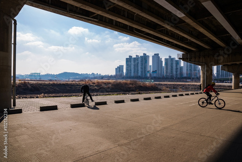 Canvas Print Cyclists under bridge