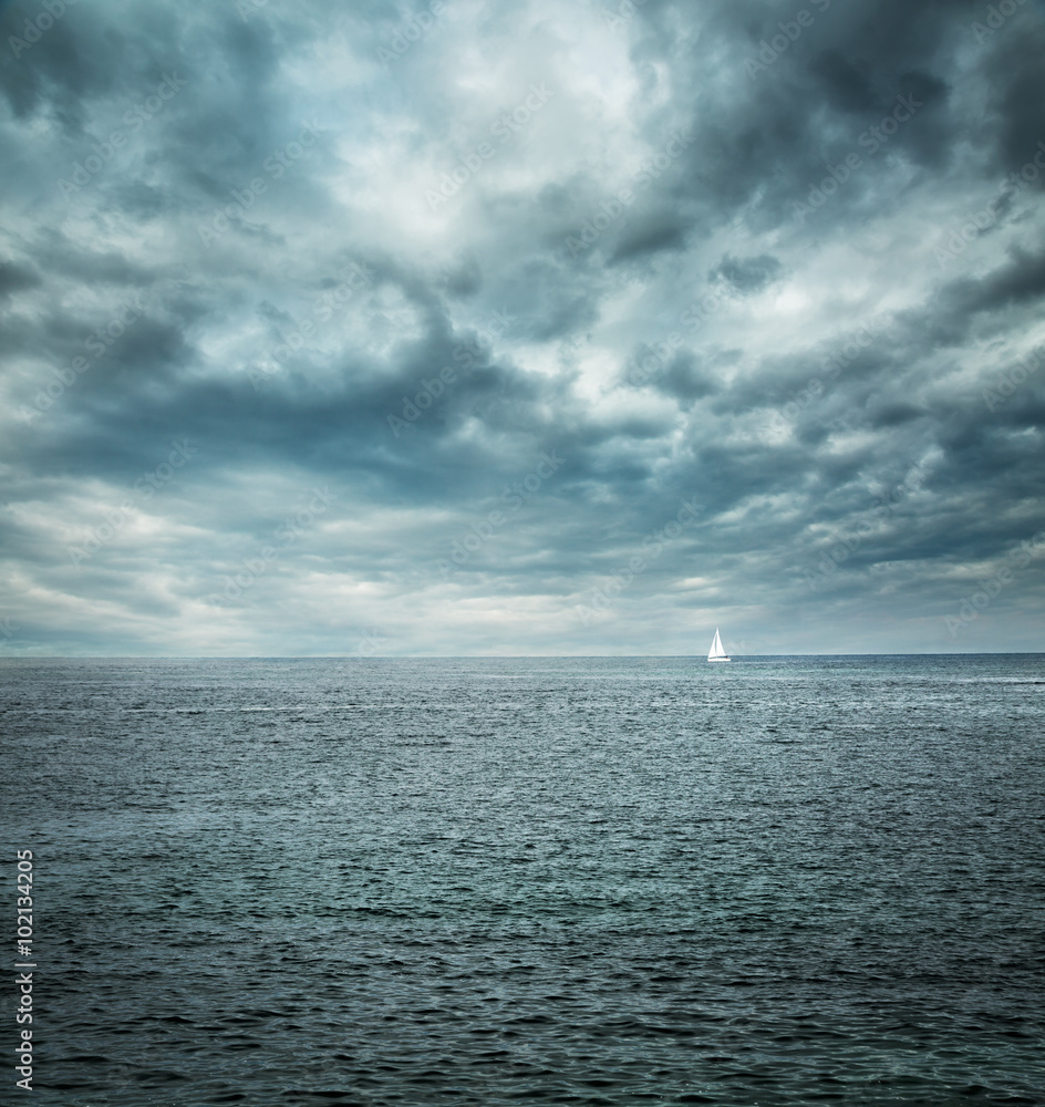 Fototapeta premium Sailing Boat at Stormy Sea. Dark Background.
