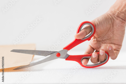 Woman hand holding red scissors and letter