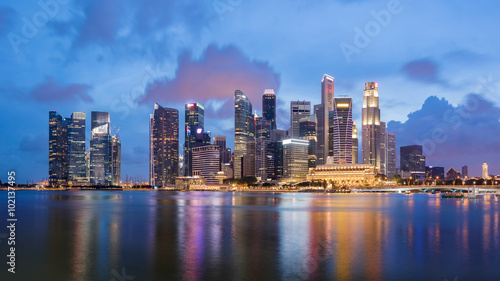 Colorful Singapore business district skyline after sun set at Marina Bay. Panoramic image. © tanarch