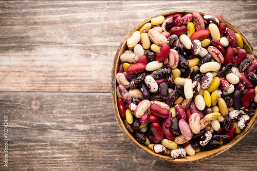 Beans  on the bowl and wooden background. © gitusik