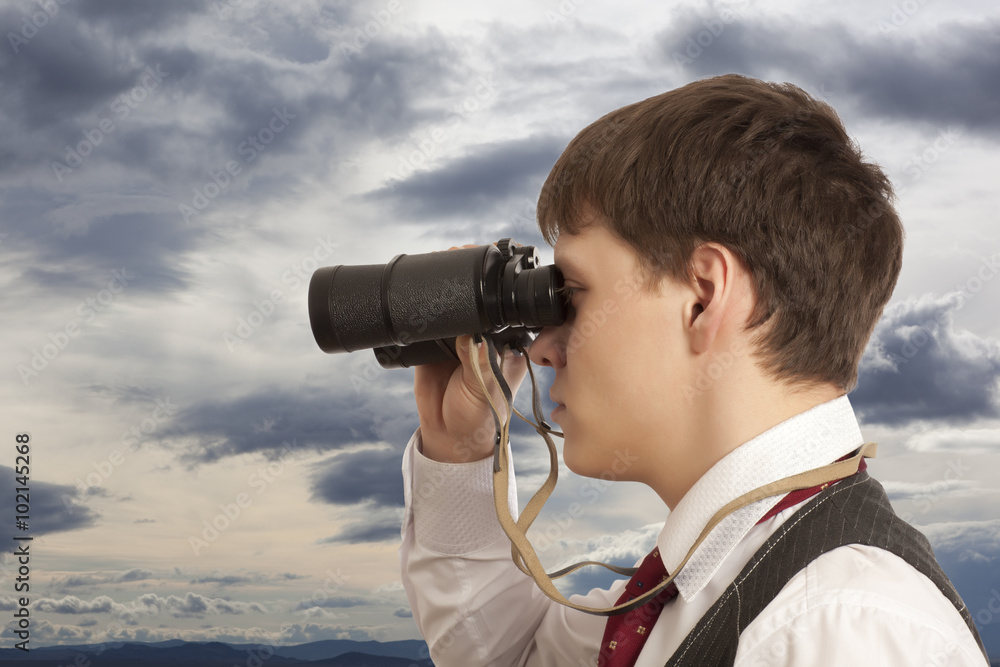 Businessman looks through a binoculars