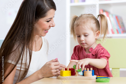 mother and kid playing logical toys at home