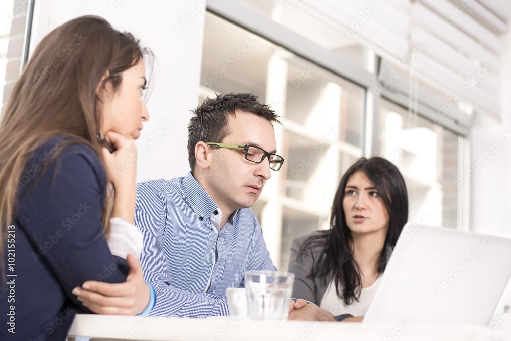 Business people interacting, discussing and sharing ideas in bright modern office. Focus on man in the middle Business people interacting, discussing and sharing ideas in bright modern office. Focus on man in the middle