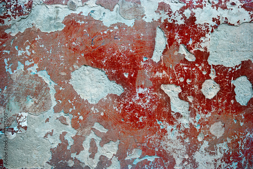 Old dirty nasty plaster and red paint on the wall surface