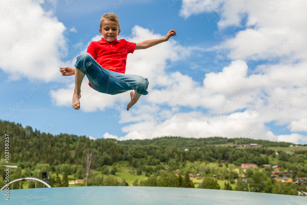 Young boy jumping on bouncing pillow Young boy jumping on bouncing pillow