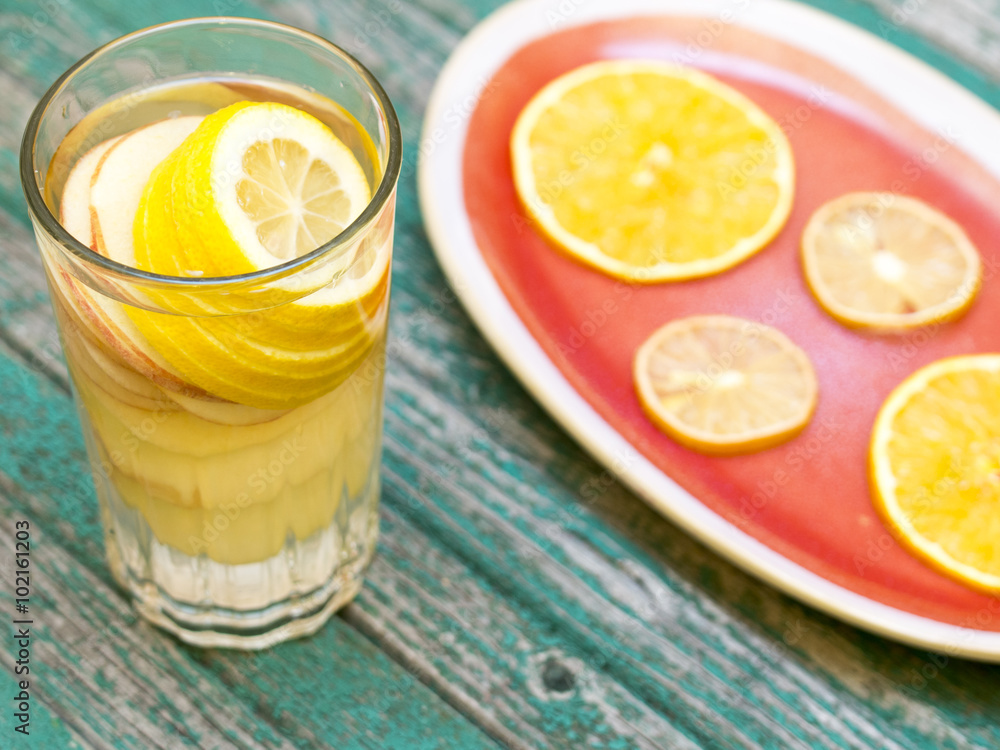 Detox water with lemon and apple in a glass on a wood background Detox water with lemon and apple in a glass on a wood background