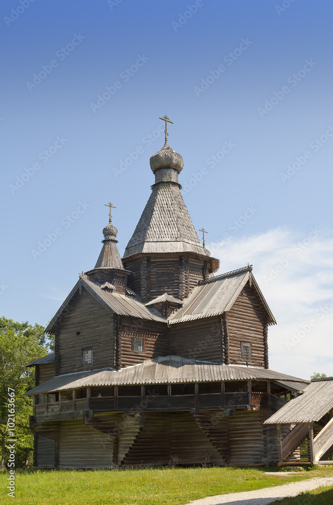 Fototapeta premium Ancient wooden church on a forest glade. Russia.