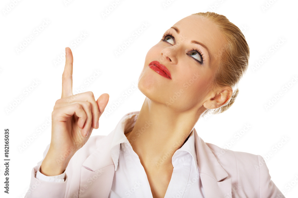 Young smiling business woman pointing up