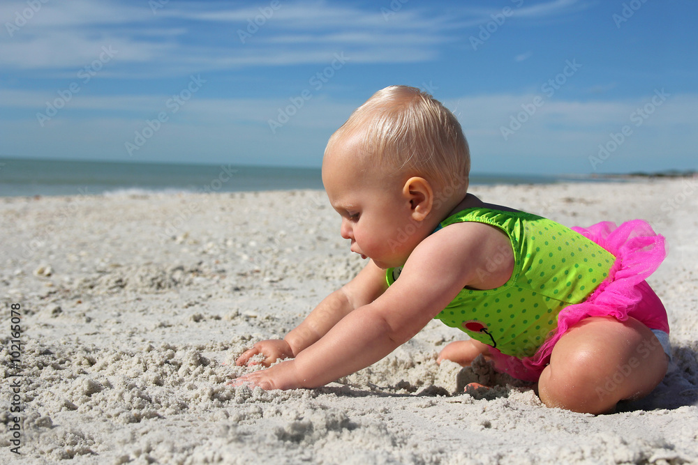 Cute Baby Girl Playing in the Sand at the Beach Cute Baby Girl Playing in the Sand at the Beach