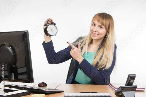 Office specialist in after-hours shows the clock