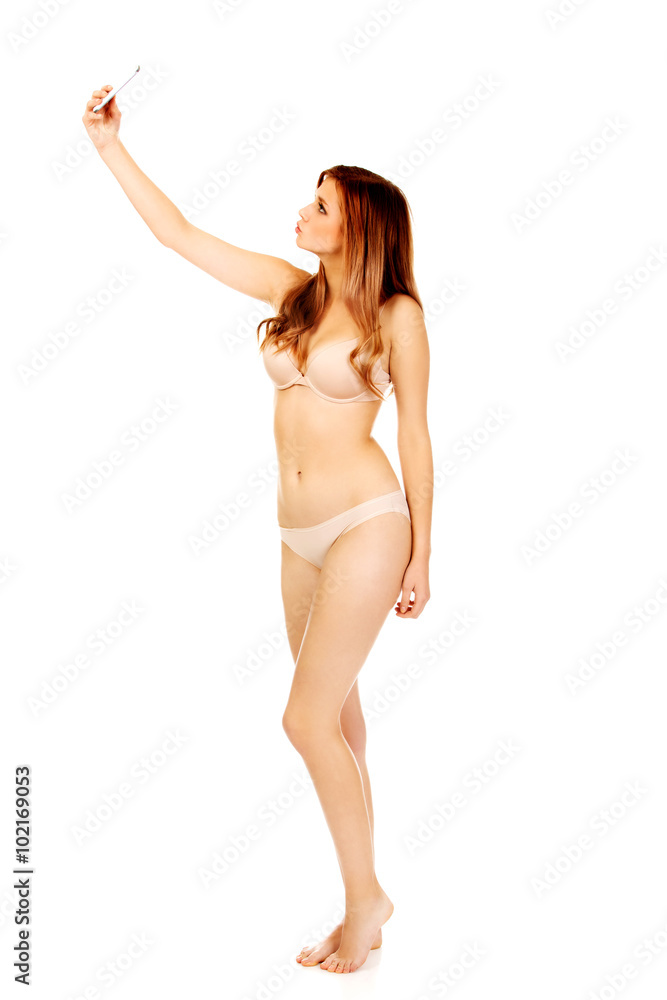 Fototapeta premium Teenage woman in underwear makes photo of herself