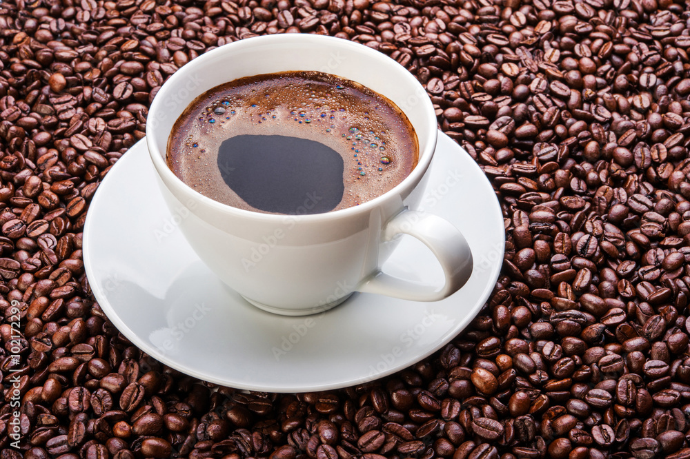 White cup of coffee on coffee beans White cup of coffee on coffee beans