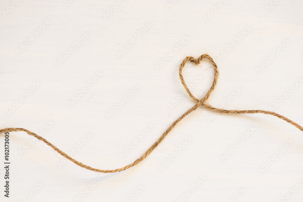 Heart made from string on white background