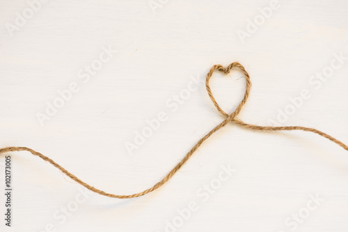 Heart made from string on white background
