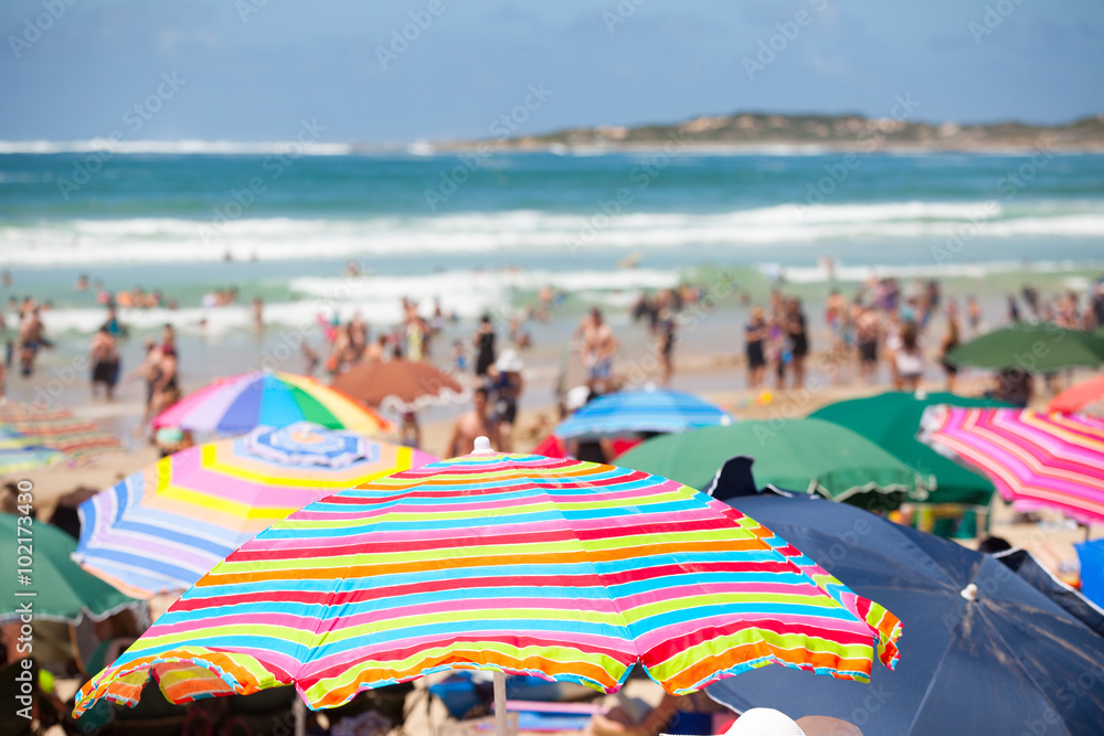 Beach scene with colorful umbrellas and people on the beach Beach scene with colorful umbrellas and people on the beach