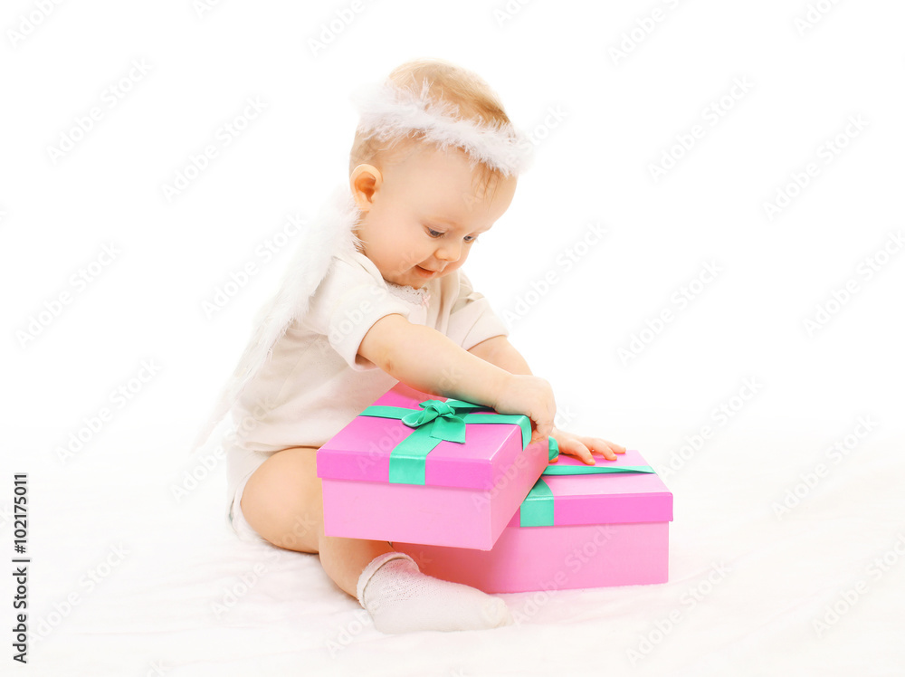 Baby playing with gift boxes on a white background Baby playing with gift boxes on a white background