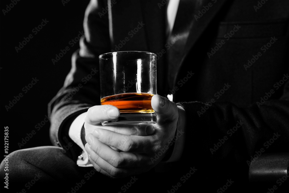 Closeup of serious businessman holding  whiskey illustrate executive privilege concept. 