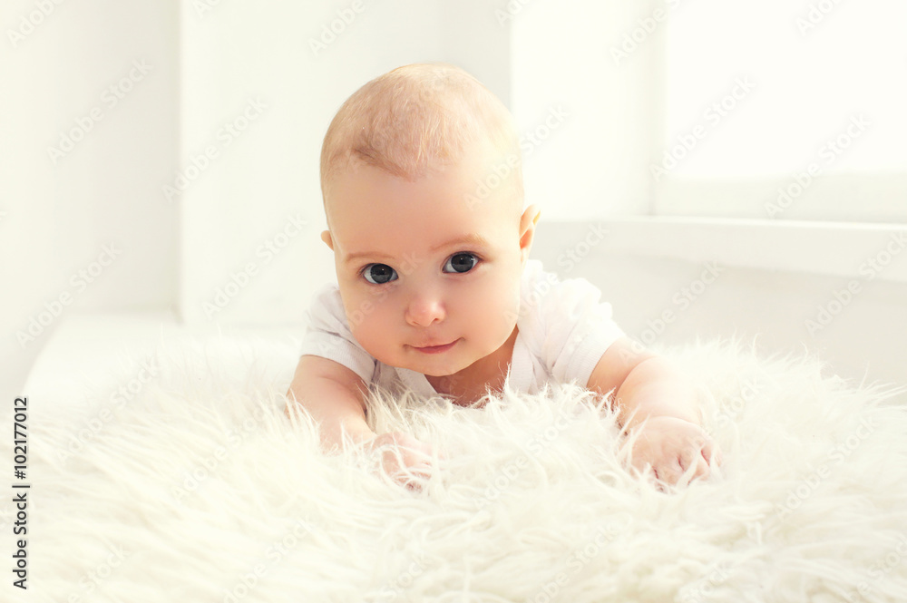 Portrait cute baby lying in white room near window Portrait cute baby lying in white room near window