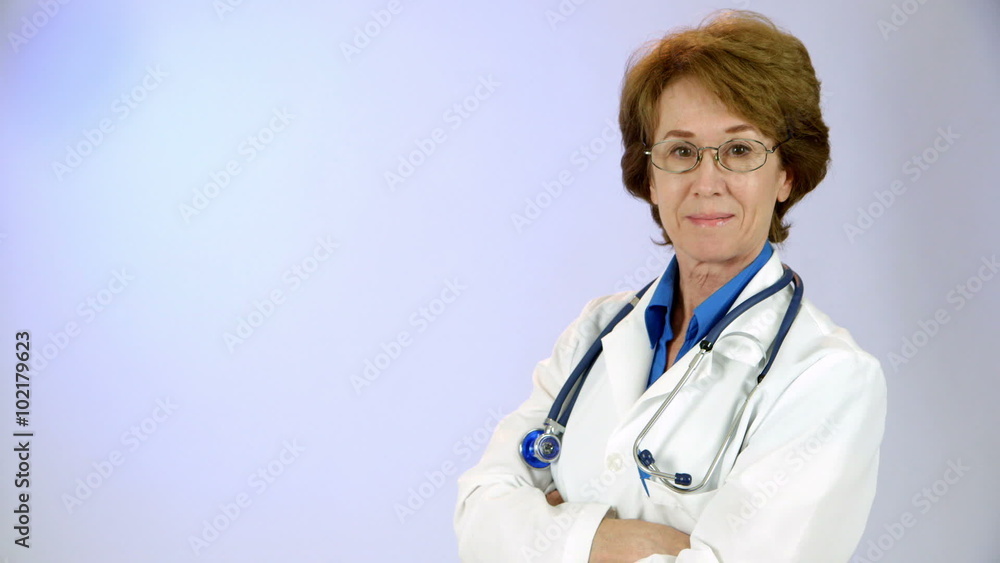 A mature female doctor looks into the camera and smiles with confidence. A mature female doctor looks into the camera and smiles with confidence.