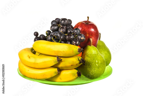 Mix fruit on green plate isolated on white background