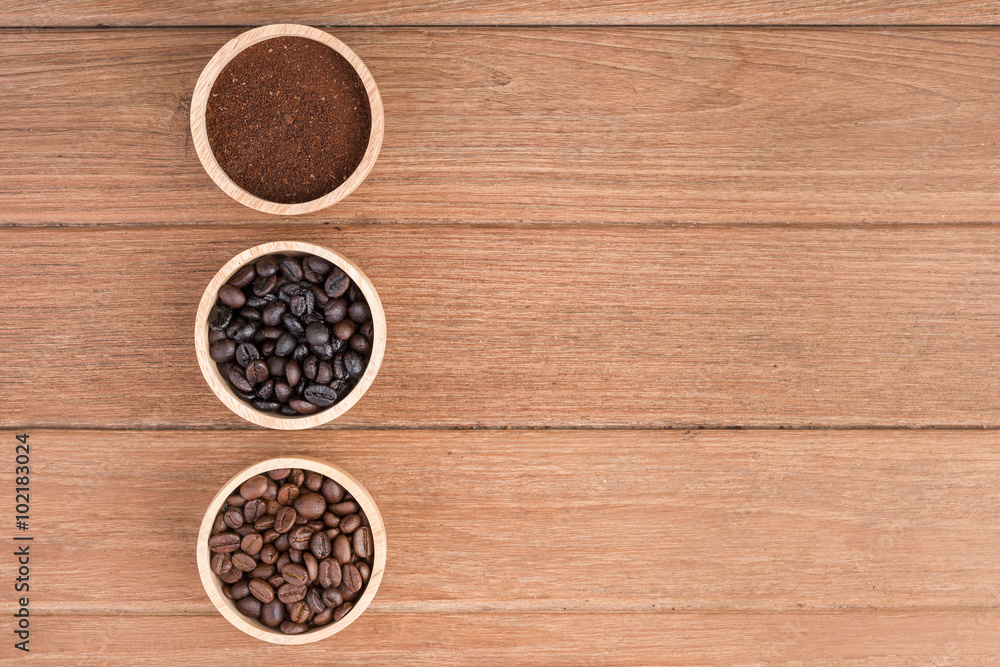 Coffee powder and coffee beans in the wood bowl on the wooden table Coffee powder and coffee beans in the wood bowl on the wooden table