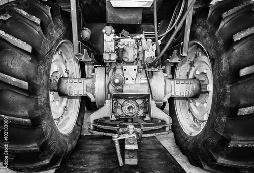 Φωτογραφία Large rear tractor tires connected by an axle in black and white