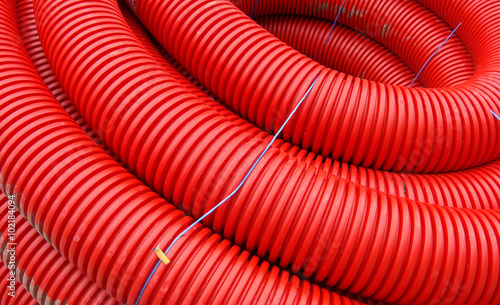 red rolled up wire pipe on an industrial construction site