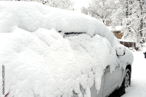 car covered under snow after blizzard in residential area