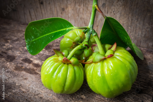 Still life with fresh garcinia cambogia on wooden background  photo