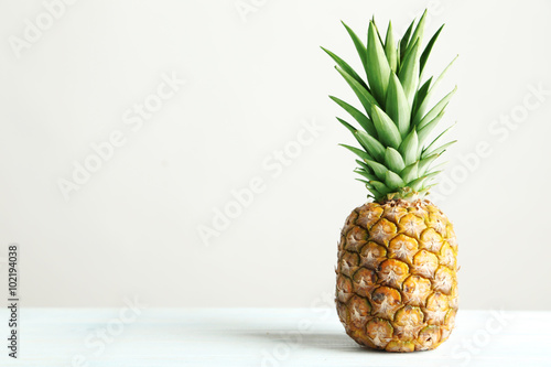 Ripe pineapple on a white wooden table