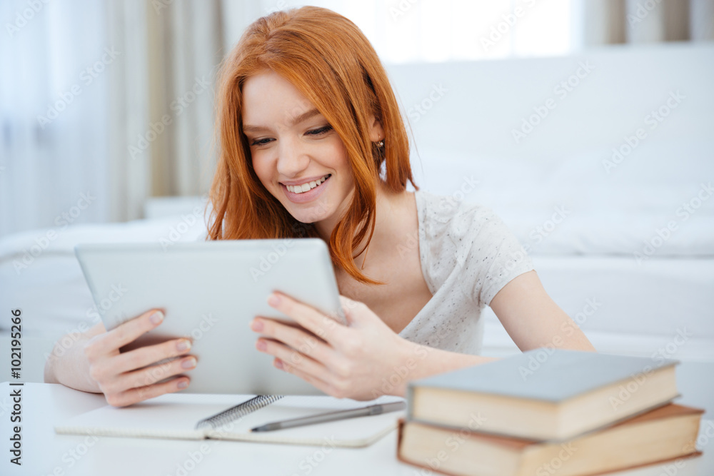 Redhead woman sitting at the table with her homework Redhead woman sitting at the table with her homework
