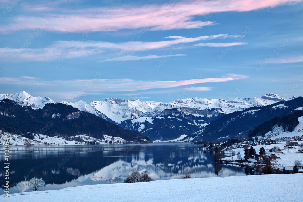 Winterliches Bergpanorama mit Sihlsee im Vordergrund, Spiegelungen im See, blaue Stunde Winterliches Bergpanorama mit Sihlsee im Vordergrund, Spiegelungen im See, blaue Stunde