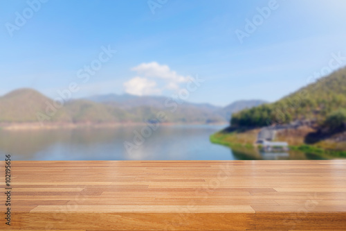 Empty wooden table and landscape background of lake and sky
