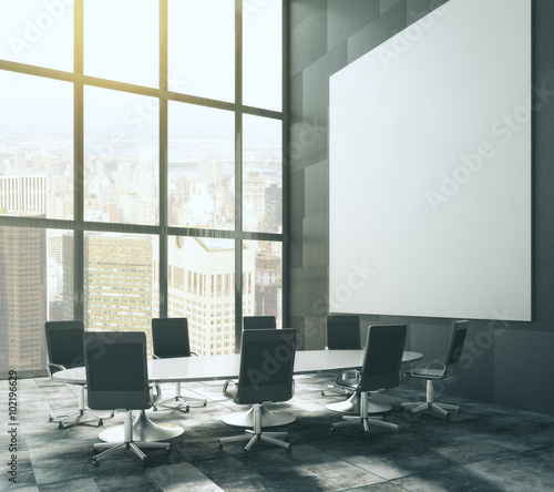 Dark meeting room with blank picture frame and table, mock up