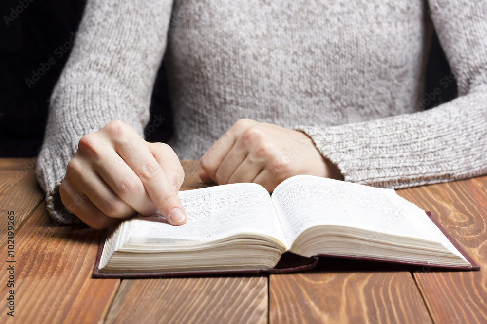 Closeup woman hand holding pocket book to read Closeup woman hand holding pocket book to read