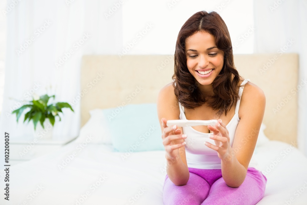 Happy woman looking at her pregnancy test Happy woman looking at her pregnancy test