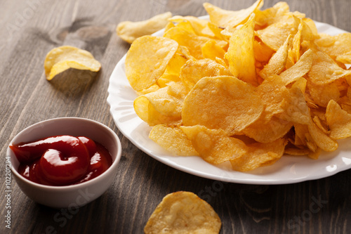 Plate of crispy chips with spicy sauce